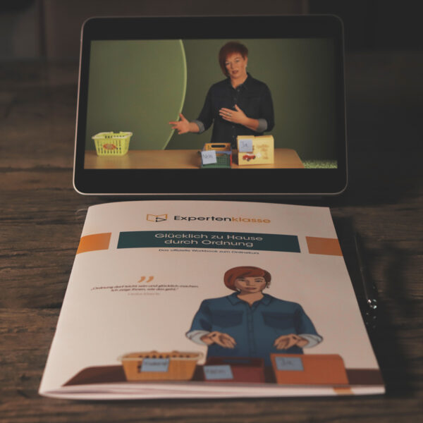 Workbook auf dem Tisch und Video auf dem iPad